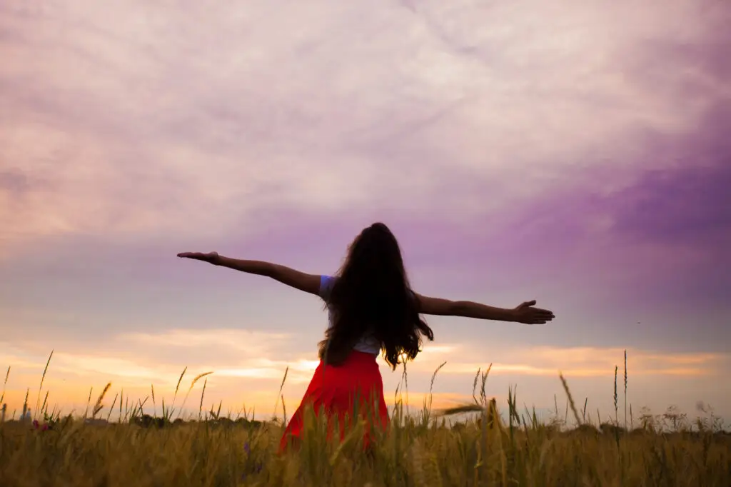 Woman claiming space with hands to sky