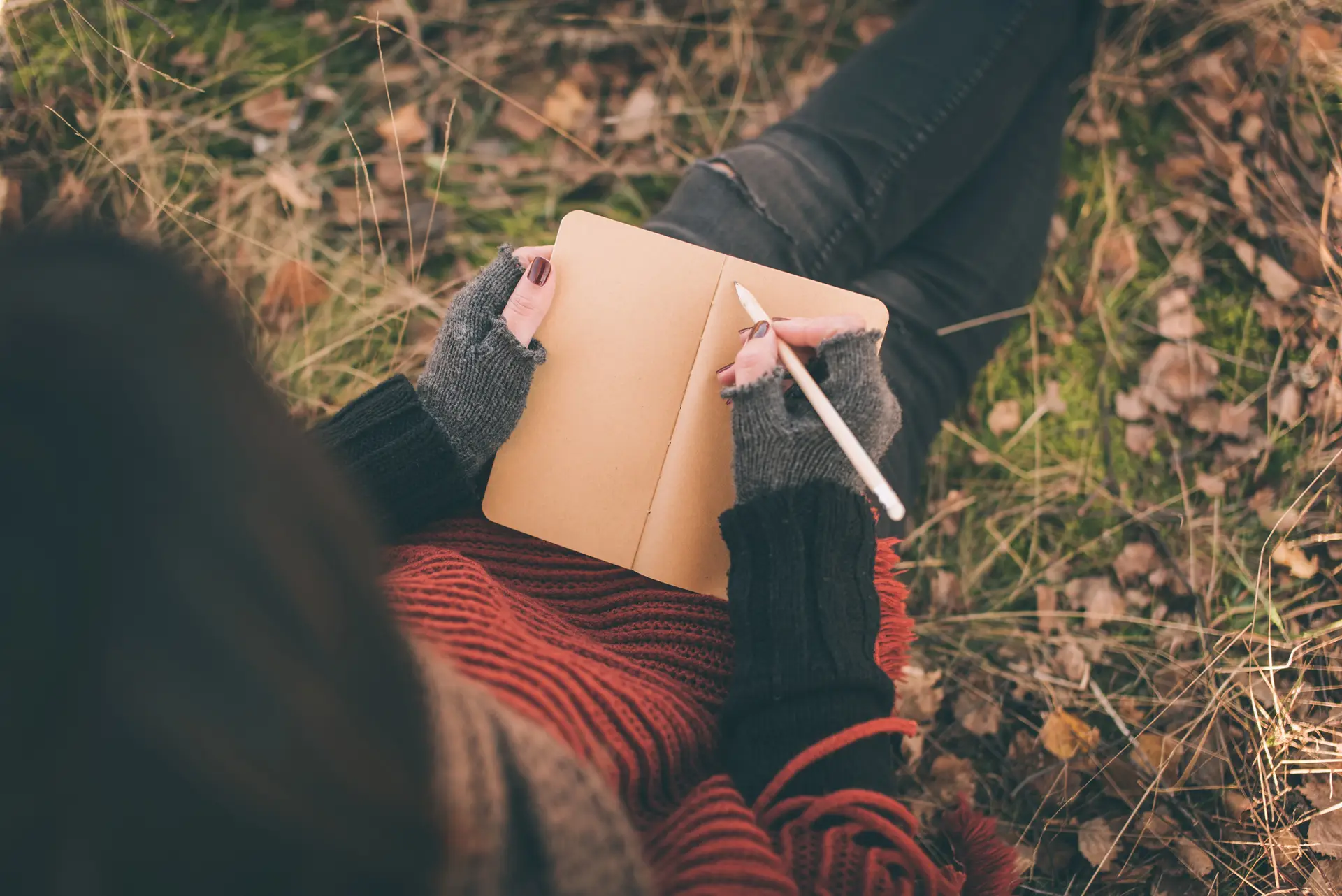 Person journaling outdoors as part of a reflective practice