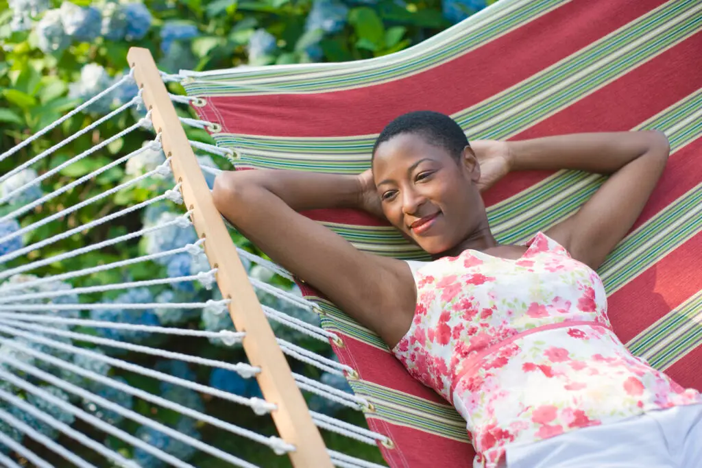 Woman relaxing in hammock, smiling, relaxed