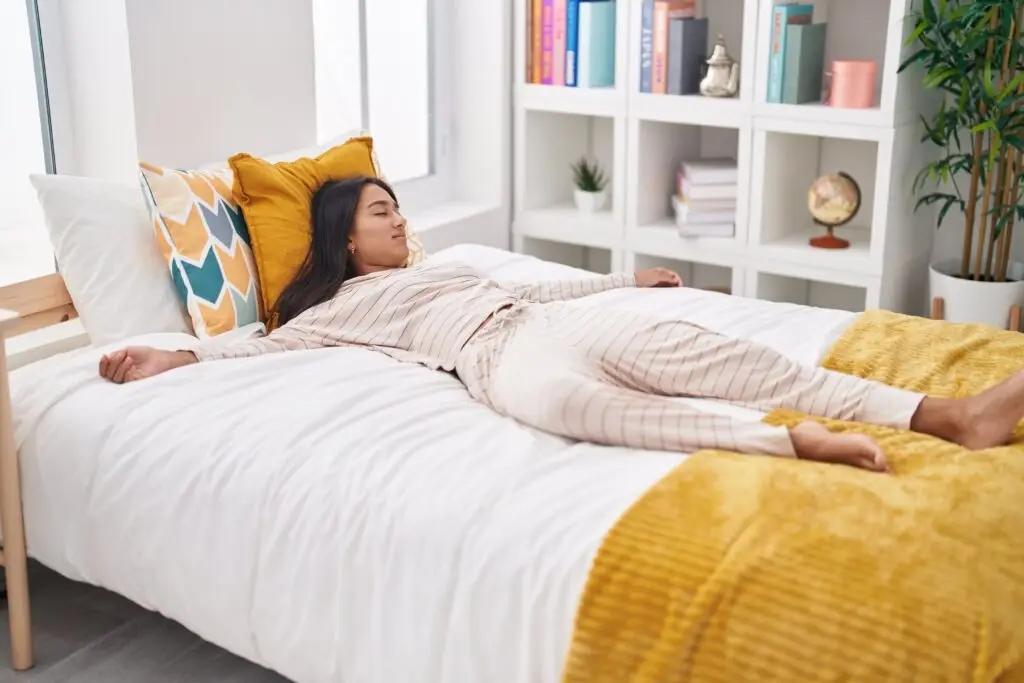 Woman resting comfortably in bed as part of a guided relaxation practice for better sleep.