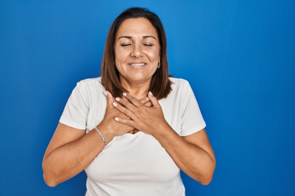Woman with hands on heart practicing mindful body awareness