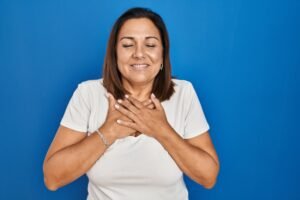 Woman with hands on heart practicing mindful body awareness