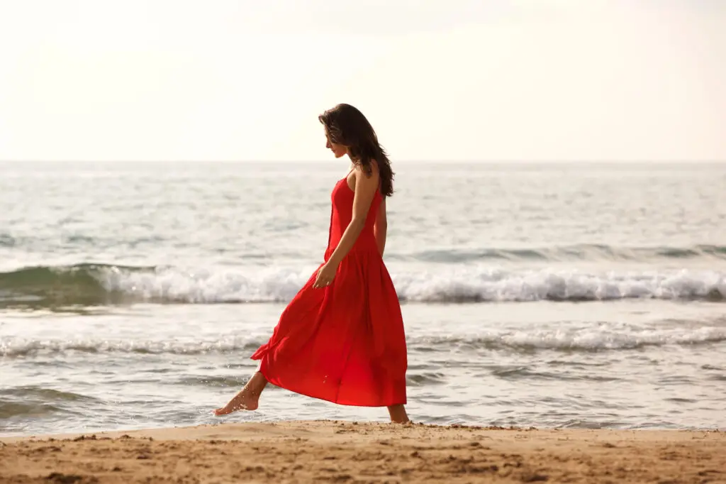 Woman walking mindfully along the beach during a meditation practice.