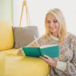 Woman journaling at home during a quiet moment of reflection.