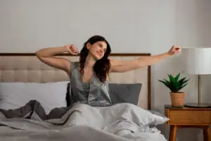 Woman stretching in bed after a restful night's sleep.