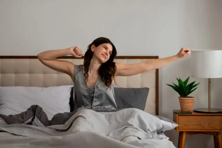 Woman stretching in bed after a restful night's sleep.