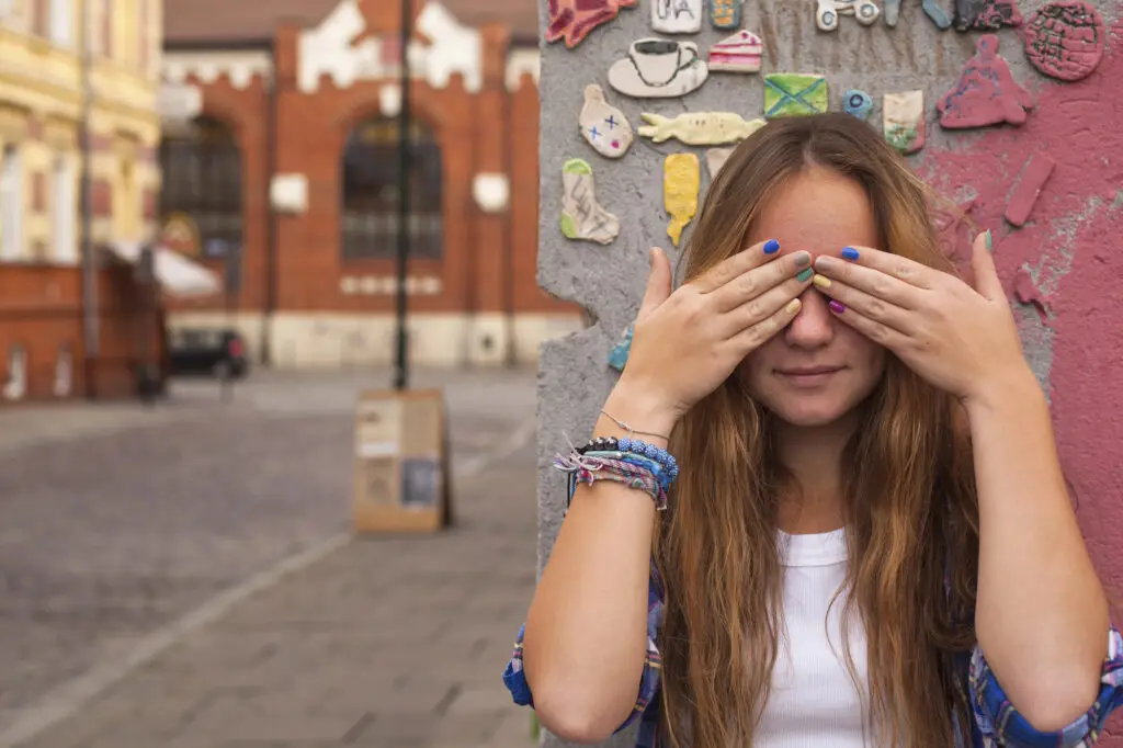 Woman covering her eyes outdoors