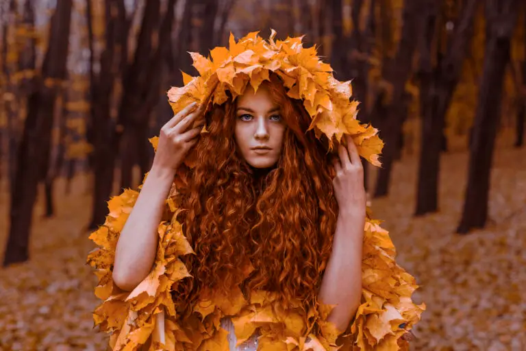 Woman surrounded by vibrant orange autumn leaves